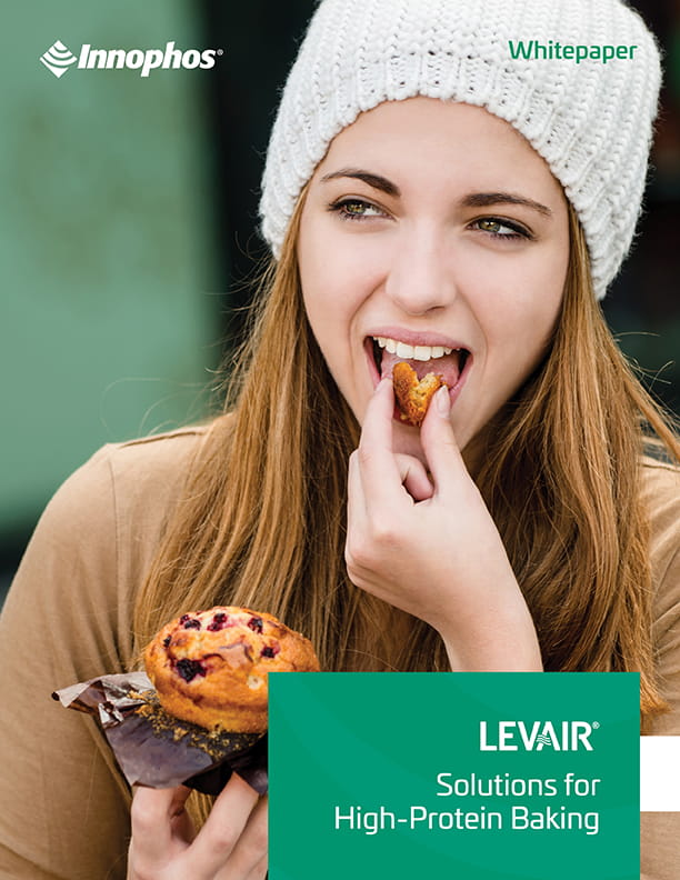 A woman biting from a piece of muffin