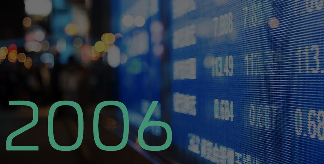 Green “2006” over a blurred stock market display background.