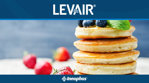 Stack of pancakes topped with blueberries and mint.