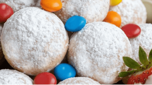 Powdered sugar-covered cookies with colorful candy-coated chocolates and a strawberry