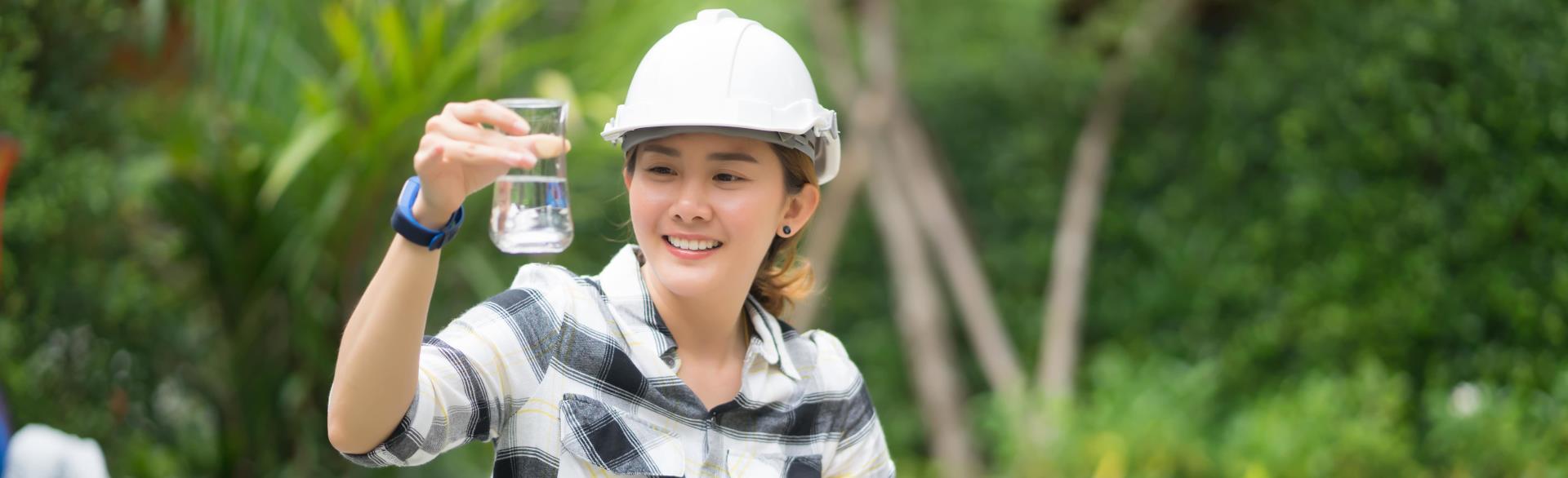 Water Treatment - Woman with beeker examining water