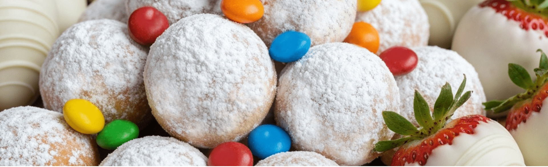 powdered sugar pastries with candy and white chocolate strawberries