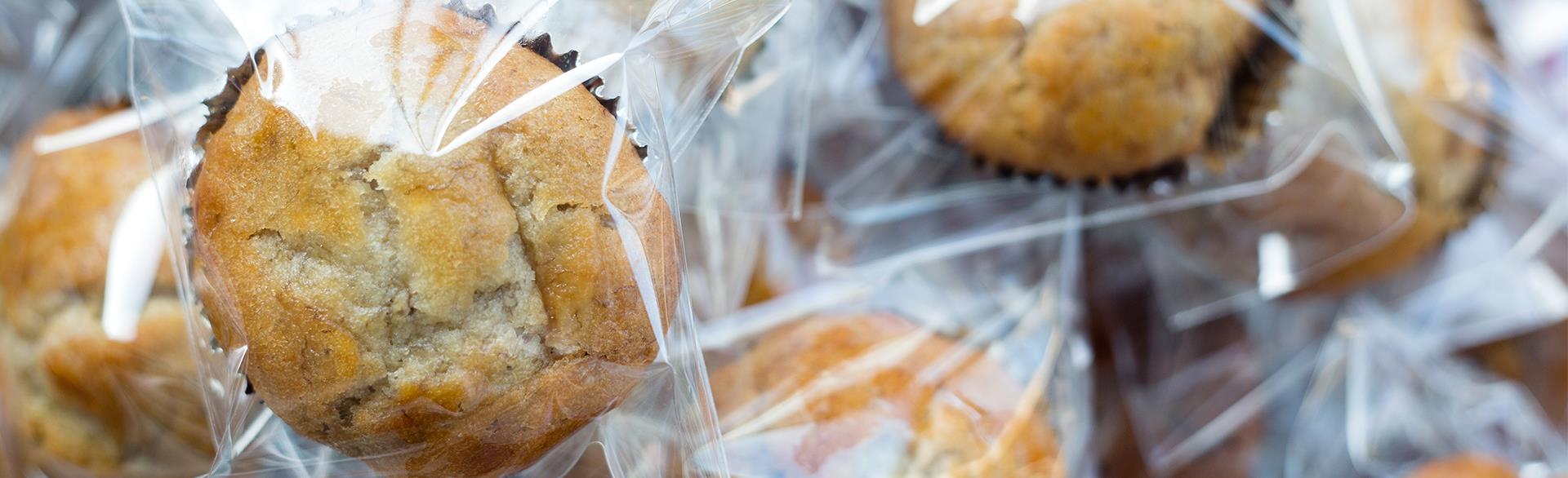 Individually wrapped golden brown muffins with cracked tops