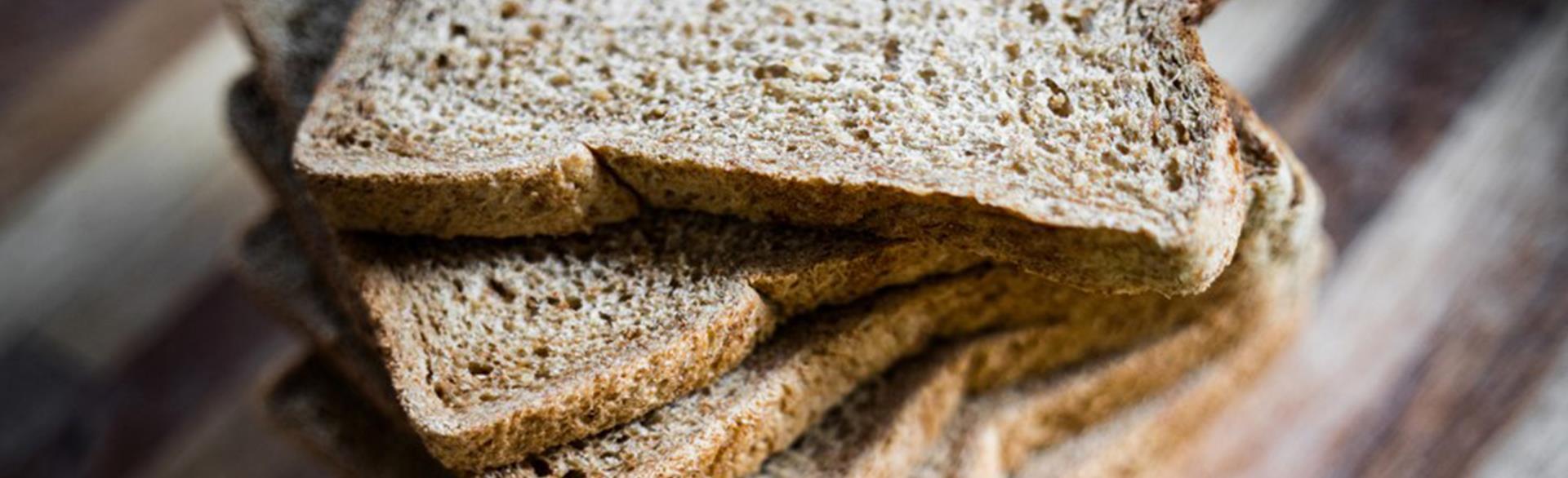 A close-up of stacked whole grain bread slices.