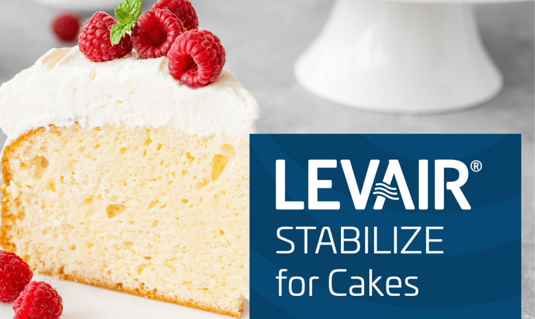 Slice of cake with white frosting and raspberries next to text 'LEVAIR® STABILIZE for Cakes'