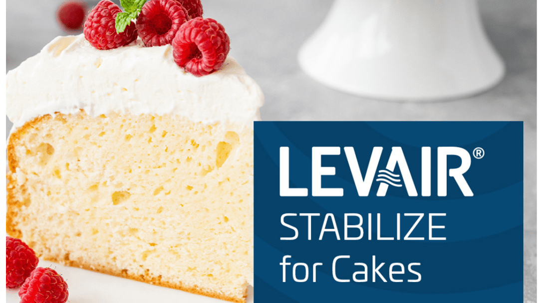 Slice of cake with white frosting and raspberries next to text 'LEVAIR® STABILIZE for Cakes'