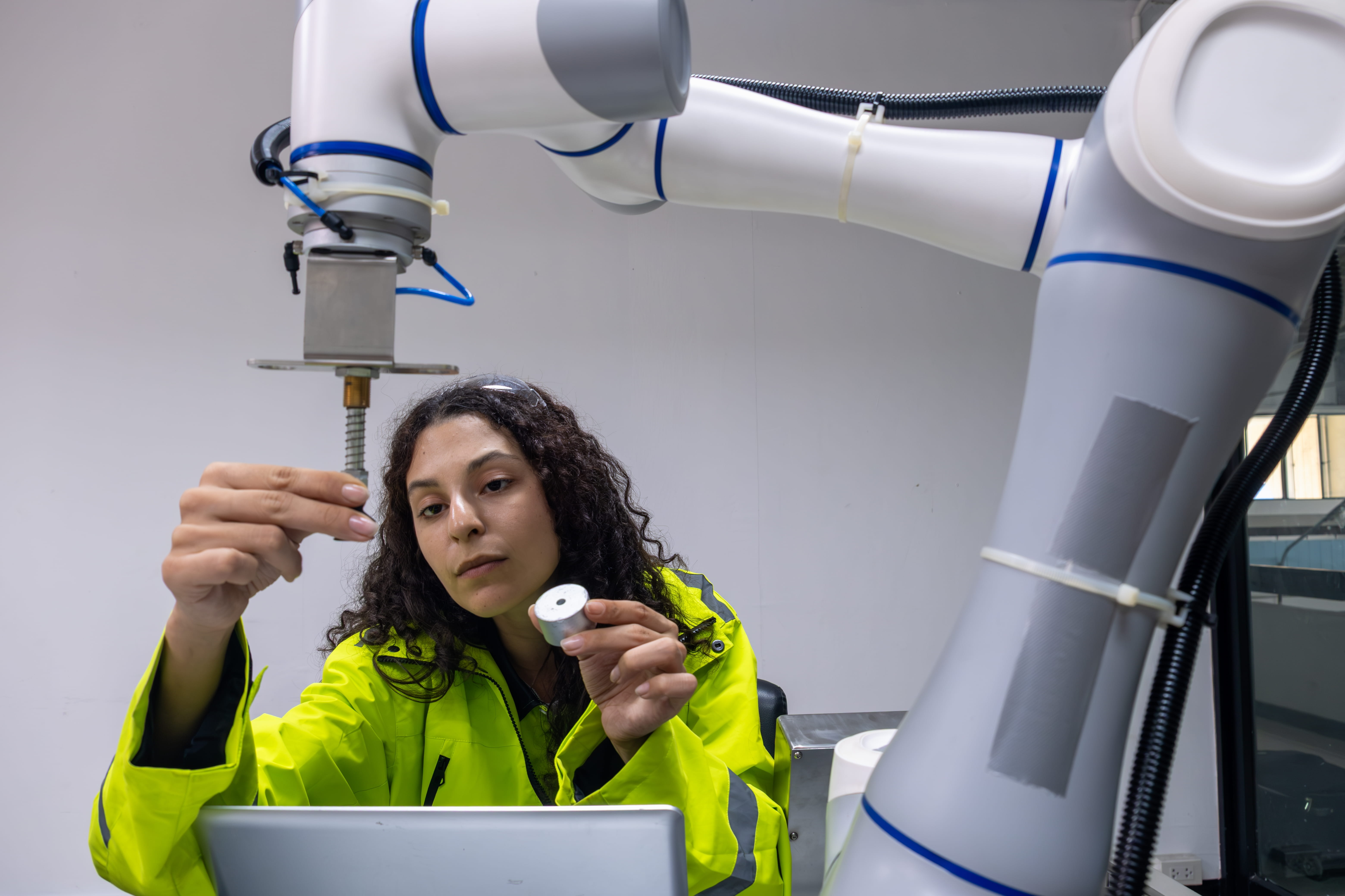 Technician operating a robotic arm in a lab
