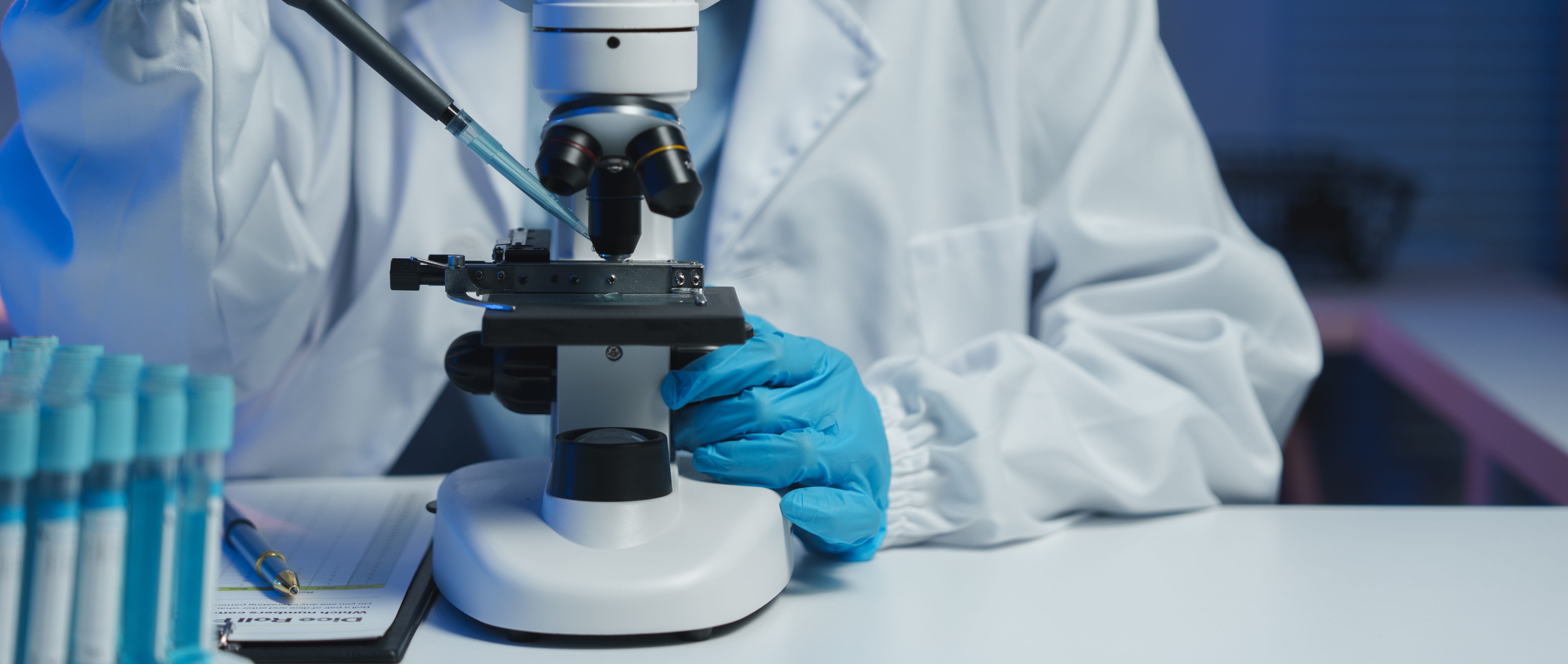 Scientist working with a microscope and test tubes